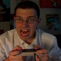 guy in glasses holding a video game controller and shouting angrily