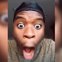 Man wearing a do rag looking at the screen with a gaping mouth