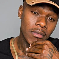 DaBaby Dababy - Jonathan Lyndale Kirk looking at the camera, tattooed hand on chin.