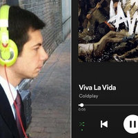 mayor pete wearing a black jacket and a red tie wearing blue headphones