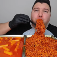 Nikocado eating from a tray of noodles