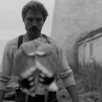 Ephraim Winslow (portayed by Robert Pattinson) looks at a seagull in the 2019 film The Lighthouse