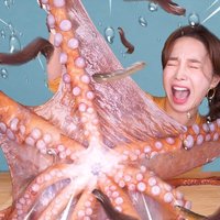 Ssoyoung Woman shouting with her eyes closed while tearing apart a living octopus