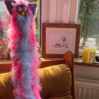 Long Furby Wife Guy pink and purple long furby in a cozy chair