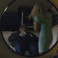 Rudy Giuliani lying on his bed while a woman stands in front of him