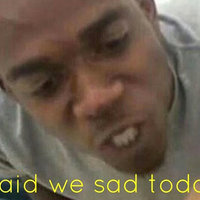 An african american man in a grey shirt with a watch on staring at another person with his mouth clenched in angry way