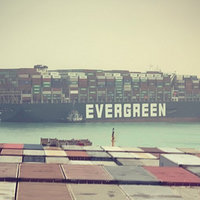 Suez Canal Jam showing a shipping freighter stuck sideways in the canal.