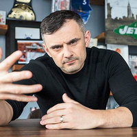 Photo of Gary Vee being based looking into the camera with his hand raised.