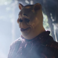 Winnie the Pooh: Blood and Honey Winnie the Pooh Blood and Honey horror movie screenshot of a man wearing a creepy winnie the pooh mask.