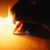 Gunna Writing Fire meme depicting a hand writing with a pen on a piece of paper as flames erupt from the tip.