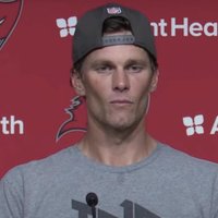 Stoned Alien Tom Brady meme depicting the football player wearing a baseball cap and speaking during a press conference.
