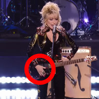 An image of Dolly Parton with a clear shot of her had, which looks like a glove. 