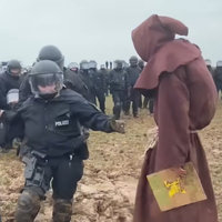 German Mud Wizard depicting a man dressed in brown robes staring down police struggling in mud.