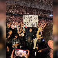 Travis I'm Pregnant Sign Travis I'm Pregnant Sign meme depicting a photo of Kourtney Kardashian at a Blink-182 concert holding up a poster.