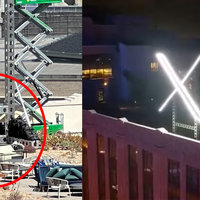 The Twitter san Francisco office's roof picturing a large x sign being held down by sandbags and flashing at night.