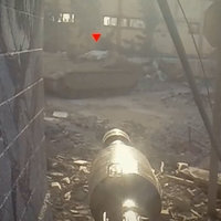 An image from a Hamas propaganda video showing someone about to fire an RPG at a tank with a red triangle marker above it.