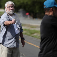 An image of the American Panama climate activist shooter firing a pistol toward another man.