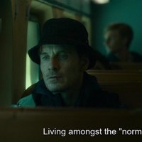 Michael Fassbender from The Killer sitting on a bus, talking about "living amongst the normies."
