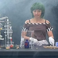 Oompa-Loompa Bartender Oompa Loompa Bartender meme depicting a woman wearing a green wig and a brown shirt taken at the Glasgow willy wonka experience.