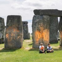 Just Stop Oil Stonehenge Protest depicting the two protestors who painted the rocks with orange paint.