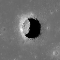 moon cave photo depicting a large crater and cave on the surface