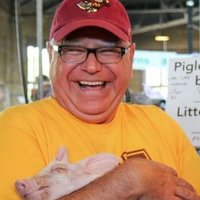 Tim Walz An image of Tim Walz holding a piglet.