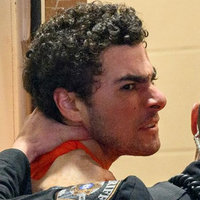 Trial of Luigi Mangione An image of Luigi Mangione being led by a police escort.