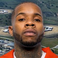 Tory Lanez mugshot edited in front of a picture of the California Correctional Institution (CCI).