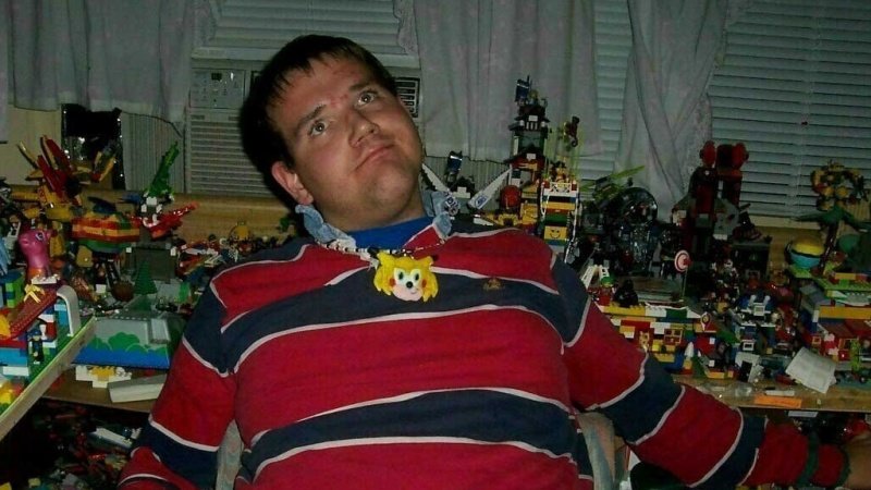 Chris Chan surrounded by lego builds and action figures.