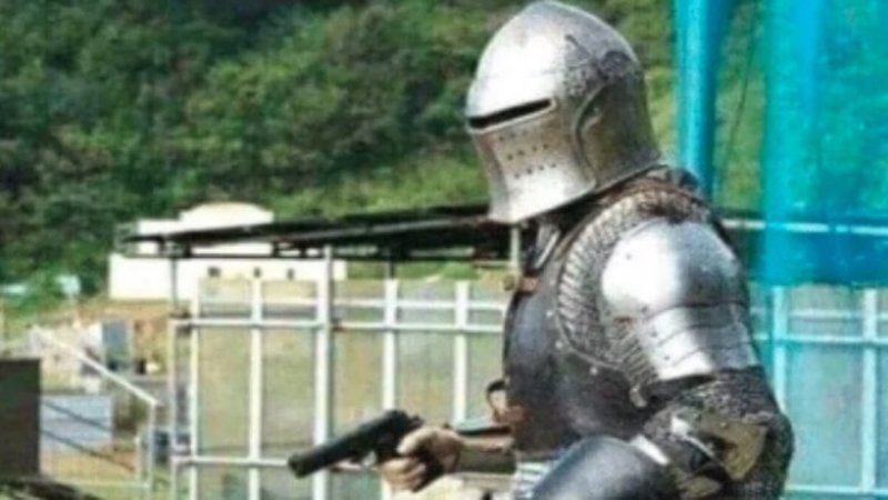 Knight in old fashioned armor holding a gun