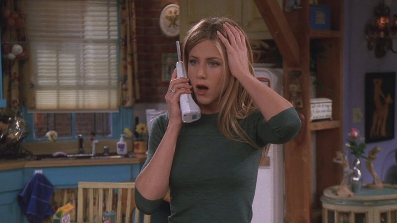 Jennifer Aniston as Rachel Green looking shocked while listening to a voicemail