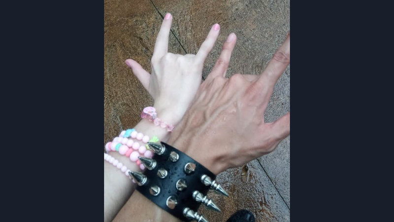 Rocker GF And BF Hands meme template and format depicting a woman's hand with pastel-colored bracelets and a man's hand with a spikey leather wrist band.