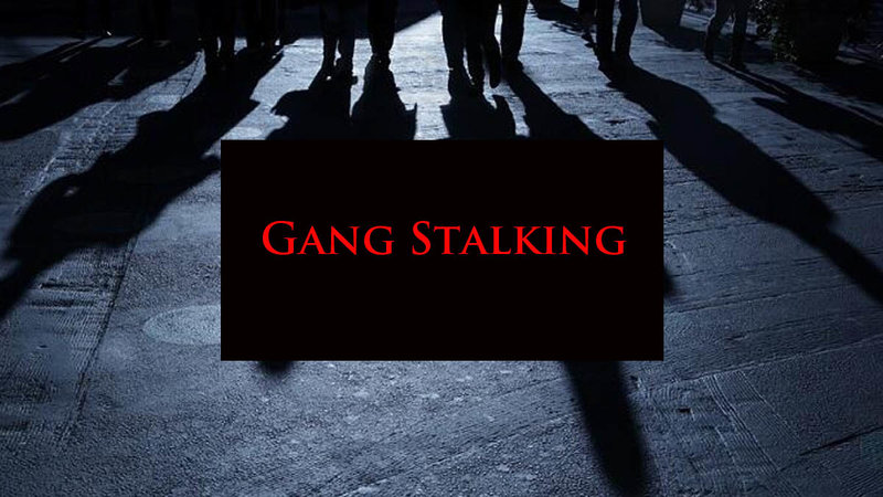 Gang Stalking conspiracy theory depicting a dark street with looming shadows.