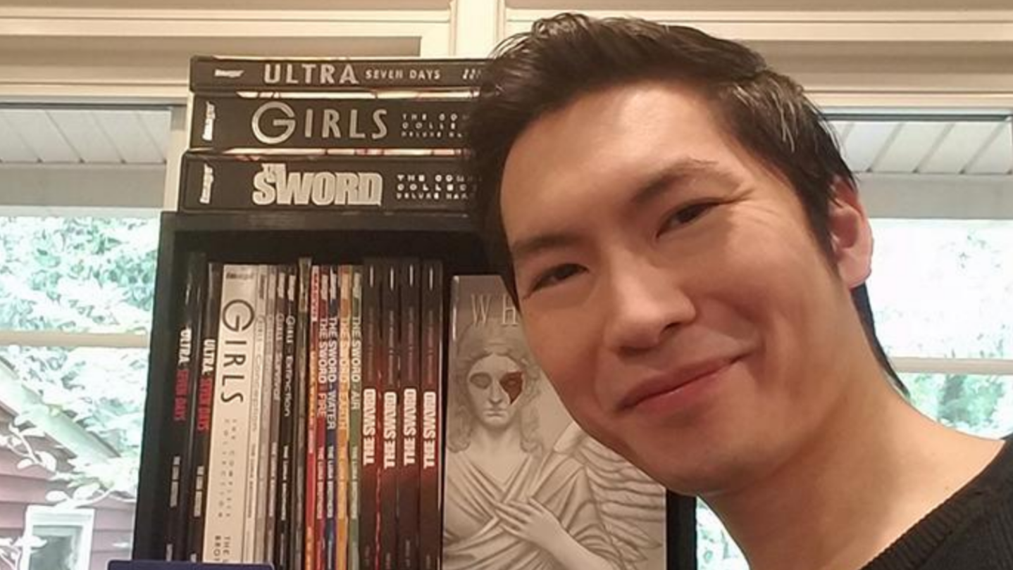 Joshua Luna in front of a shelf of books