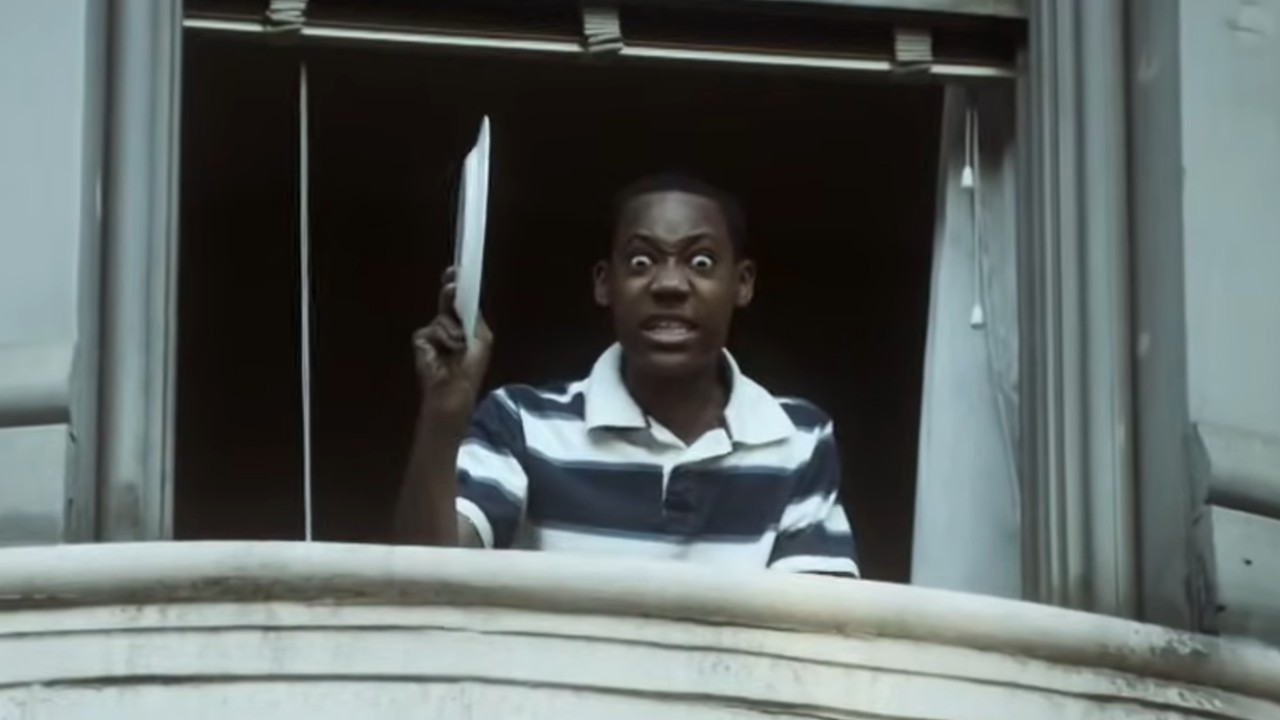 Chris from Everybody Hates Chris in a window holding a dish, ready to throw it.