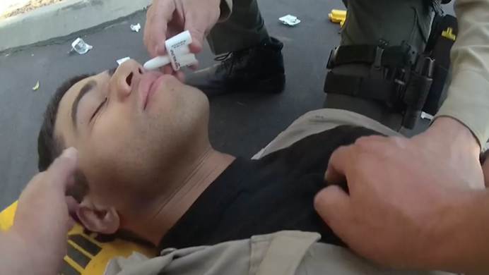cop on ground receiving treatment