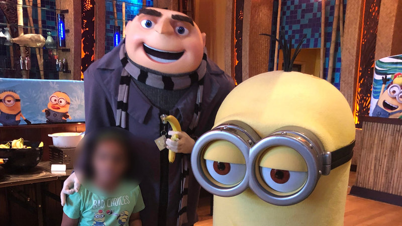 photograph of gru actor with two children at universal orlando ok symbol