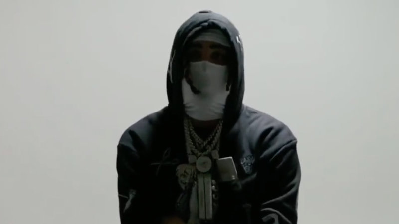 A photo of rapper Punchmade Dev holding stacks of cash.