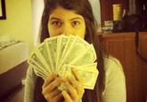 Daughter of Hugo Chavez, Rosine Chávez, posing with a fanned out stack of USD dollar bills that covers up her lower face which started the photo fad of posing with things that are scarce in Venezuela 