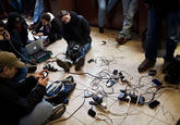 People crowd into a Chase Bank ATM kiosk to charge phones and laptops at 40th Street and 3rd Avenue, one block north of where power has gone out, on October 31, 2012 in New York City. “This is the modern campfire,” one man said. (Andrew Burton/Getty Images)