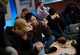 People crowd into a Chase Bank ATM kiosk to charge phones and laptops at 40th Street and 3rd Avenue, one block north of where power has gone out, on October 31, 2012 in New York City. “This is the modern campfire,” one man said. (Andrew Burton/Getty Images)