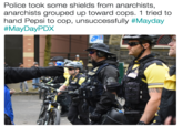 Police took some shields from anarchists, anarchists grouped up toward cops. 1 tried to hand Pepsi to cop, unsuccessfully #Mayday #MayDayPDX 5