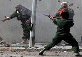 Photo from Libya, 2011, with one man firing his weapon and another playing his guitar Crazy photo from Getty Images in which a man is seen yelling, another firing his automatic weapon off screen, and a man behind the gunman that appears to be mid song in his guitar. 
Photo credit: Aris Messinis - "Getty Images":https://www.gettyimages.co.uk/detail/news-photo/libyas-new-regime-forces-fire-their-weapons-at-fighters-news-photo/162792409#libyas-new-regime-forces-fire-their-weapons-at-fighters-loyal-to-picture-id162792409