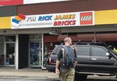 Funny picture of a man with a backpack crossing the street toward and SUV in "Australia":/memes/cultures/australia, with a store in the background that sells "Lego":/memes/subcultures/lego bricks with a sign that reads, I'm  Rick James, Bricks.