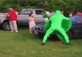 Greenman beats up a green mascot, falls comically on the ground