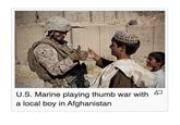 U.S. Marine playing thumb war with a local boy in Afghanistan
