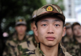 An image supposedly sourced from Stringer on Reuters but found on a December 2010 listicle on Rediff. The caption on the image reads, "A paramilitary police recruit shed tears before heading to Xinjiang Uygur Autonomous Region to start his service, at a railway station in Jiaxing, Zhejiang province, China."