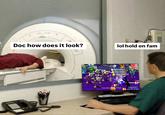 An example of the "How Does It Look, Doc?" "exploitable":https://knowyourmeme.com/memes/exploitables meme, which shows a person wearing red scrubs lying down in an MRI machine, asking, "Doc how does it look?" to which the doctor to responds, "lol hold on fam" while playing "_Five Nights At Freddy's_":https://knowyourmeme.com/memes/subcultures/five-nights-at-freddys.