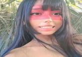 A photo of X user @SantoriMary in a costume with red face paint over her eyes. The photo was popularized through the "What Columbus Saw" meme.