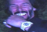 An AI-generated image of Keanu Reeves flexing a watch and grillz. The image was made by X user @TAKEOVERWW.